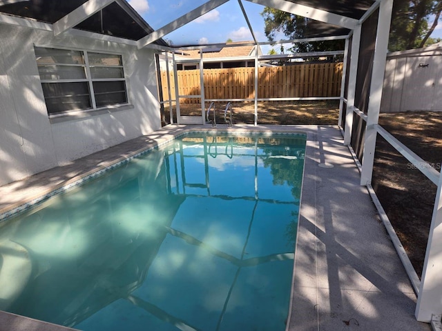 view of swimming pool featuring a lanai