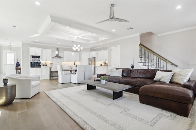 living room with crown molding, beam ceiling, coffered ceiling, light hardwood / wood-style floors, and ceiling fan with notable chandelier