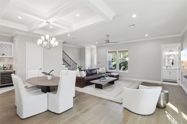 dining space with light hardwood / wood-style flooring, crown molding, and coffered ceiling