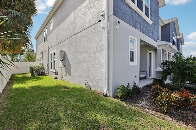 view of side of home with a yard