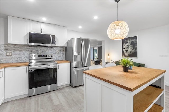 kitchen with wooden counters, white cabinets, and stainless steel appliances