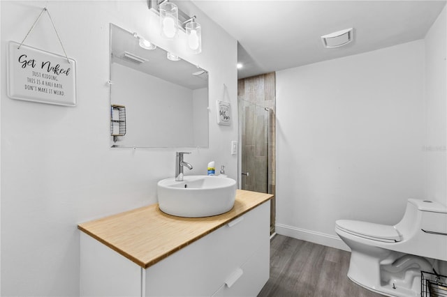 bathroom with toilet, vanity, an enclosed shower, and hardwood / wood-style flooring