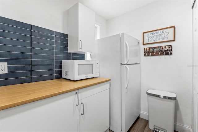 kitchen featuring white cabinetry, white appliances, backsplash, and dark hardwood / wood-style floors