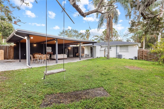 back of house featuring central air condition unit, a yard, and a patio area