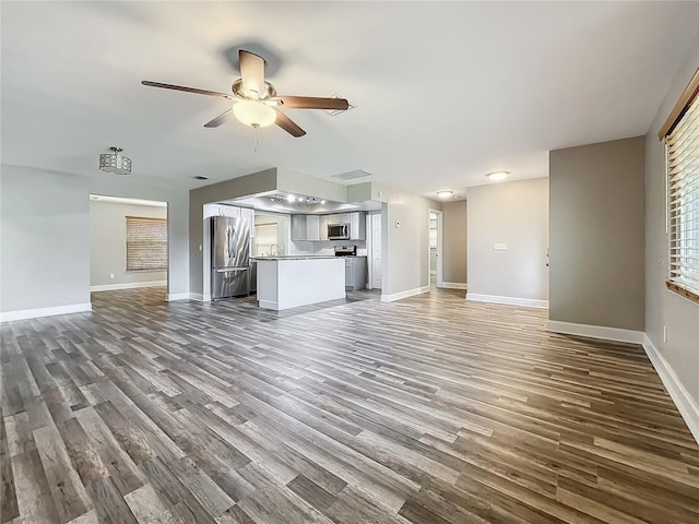 unfurnished living room with ceiling fan and dark hardwood / wood-style flooring