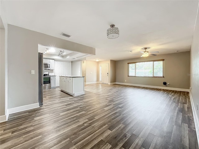 unfurnished living room featuring ceiling fan and hardwood / wood-style flooring