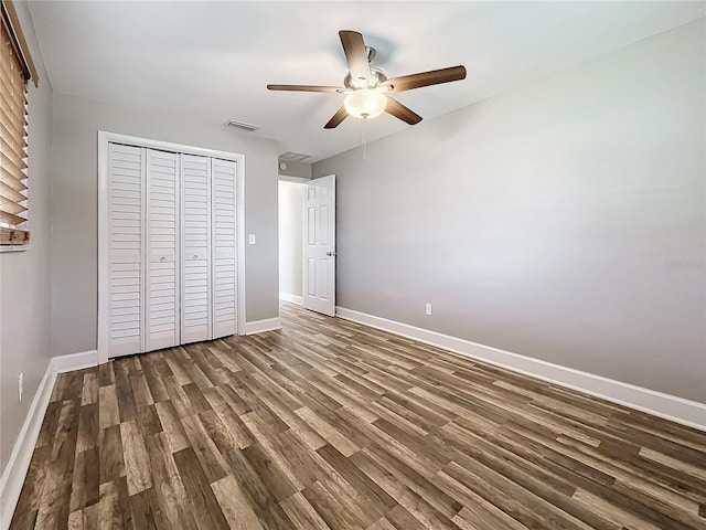 unfurnished bedroom featuring dark hardwood / wood-style flooring, a closet, and ceiling fan