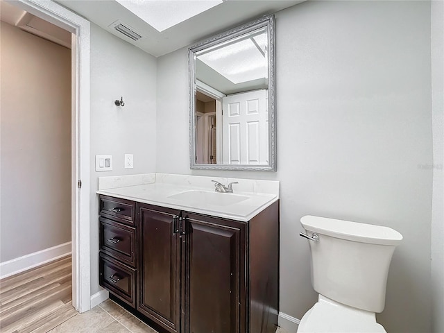 bathroom with vanity, wood-type flooring, and toilet