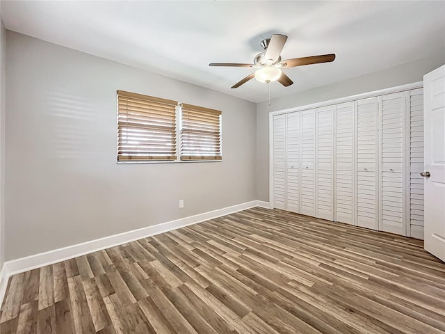 unfurnished bedroom featuring wood-type flooring, a closet, and ceiling fan