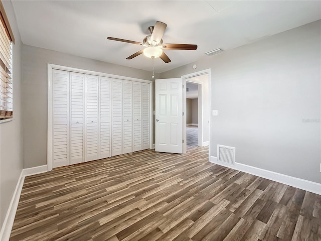 unfurnished bedroom with a closet, ceiling fan, and dark hardwood / wood-style floors