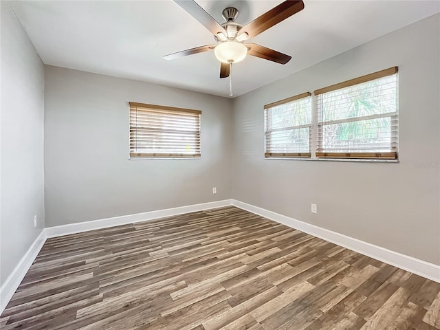 empty room with a wealth of natural light and hardwood / wood-style floors