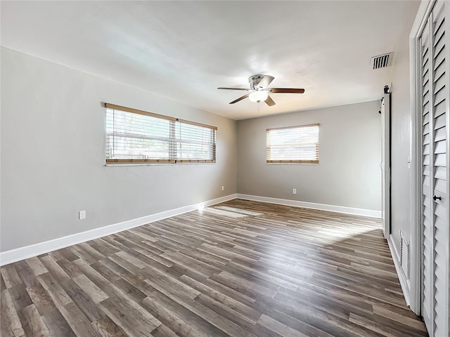 empty room with dark hardwood / wood-style floors and ceiling fan