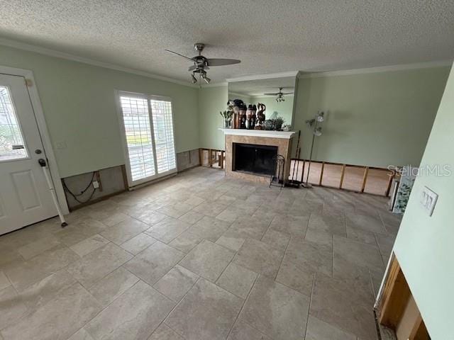 unfurnished living room featuring ornamental molding, a textured ceiling, and ceiling fan