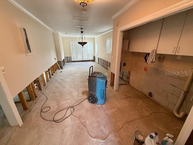 kitchen with crown molding, white cabinets, and hanging light fixtures