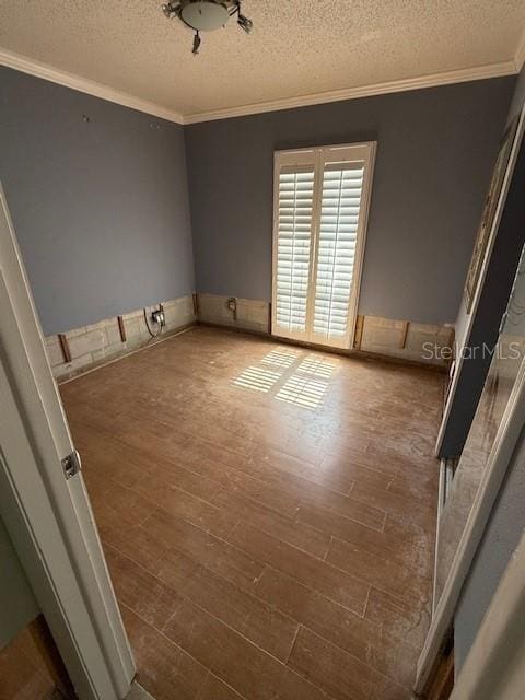 unfurnished room with a textured ceiling, crown molding, and dark hardwood / wood-style floors