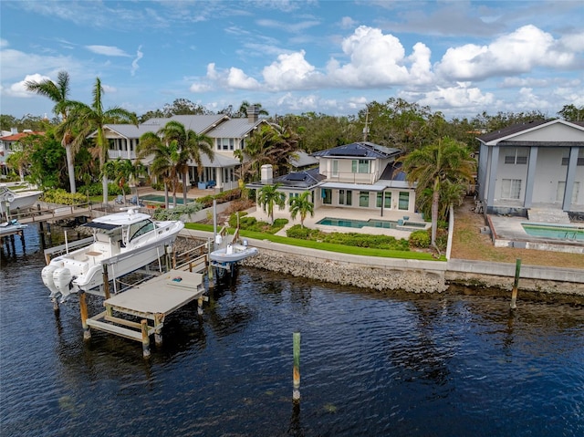 dock area featuring a water view, a swimming pool with hot tub, and a patio area