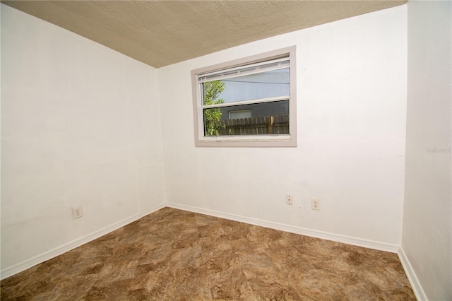 unfurnished room featuring a textured ceiling and lofted ceiling