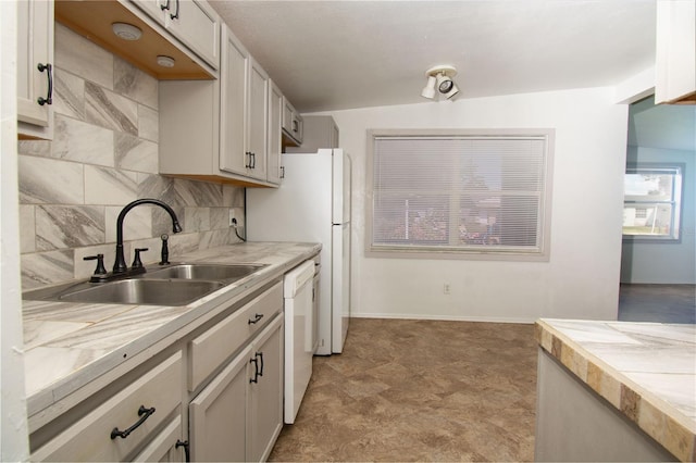 kitchen featuring tasteful backsplash, sink, and dishwasher