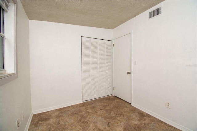 unfurnished bedroom featuring a closet and a textured ceiling