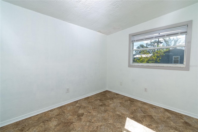 unfurnished room with a textured ceiling