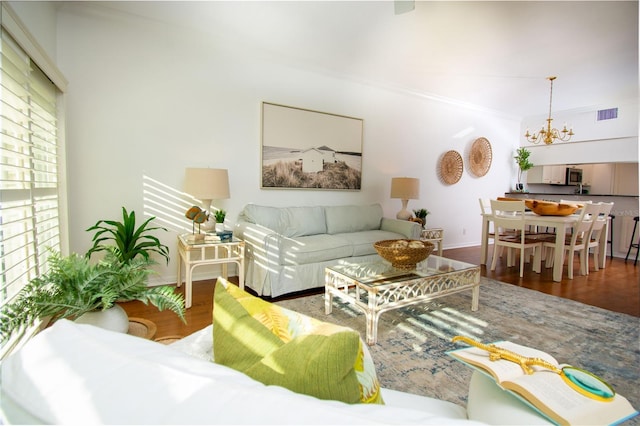 living room with a chandelier, hardwood / wood-style flooring, plenty of natural light, and ornamental molding