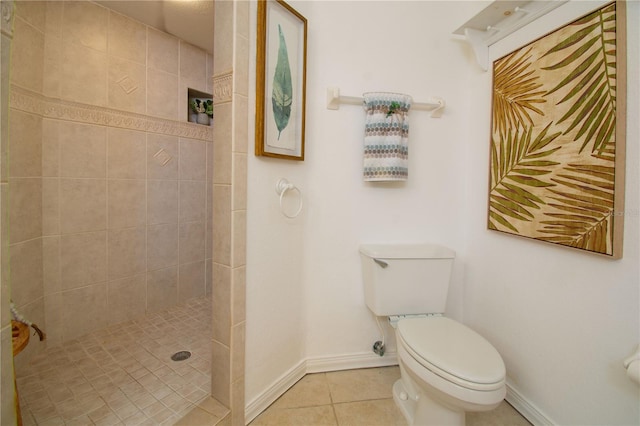 bathroom featuring a tile shower, tile patterned floors, and toilet