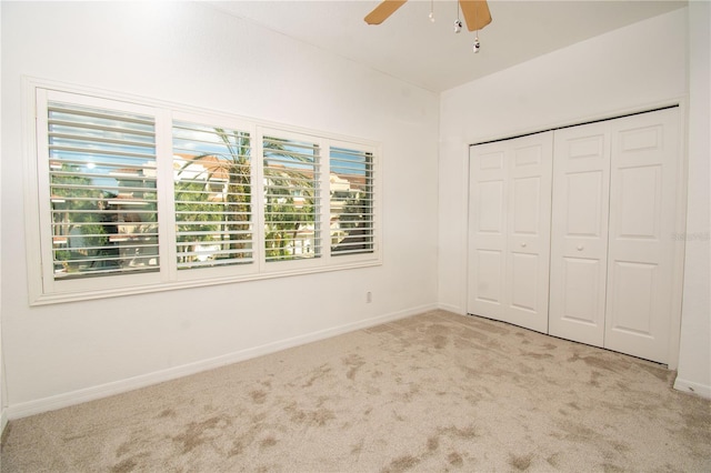 unfurnished bedroom featuring light carpet, a closet, and ceiling fan