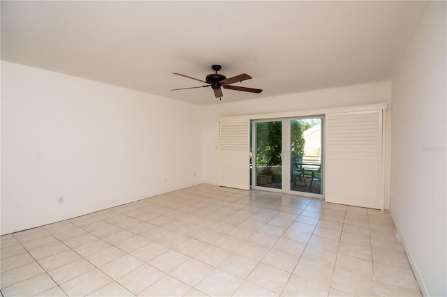 empty room with ceiling fan and light tile patterned floors