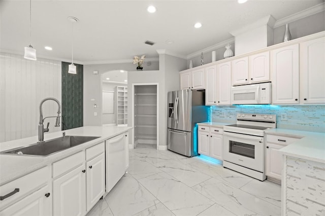 kitchen featuring crown molding, decorative light fixtures, sink, white cabinets, and white appliances