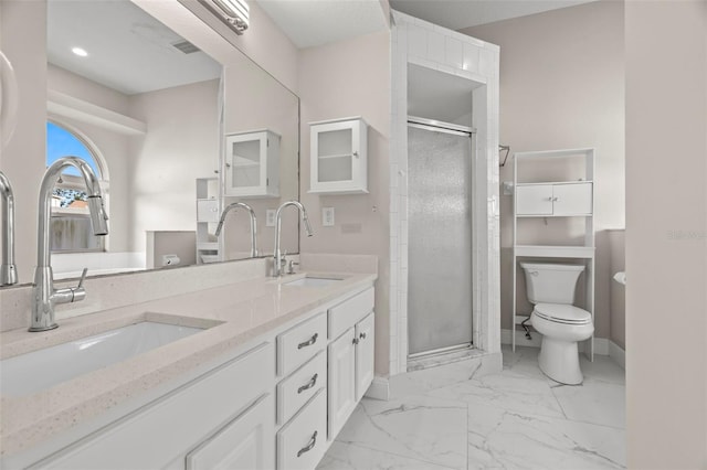 bathroom with a shower with door, vanity, and toilet