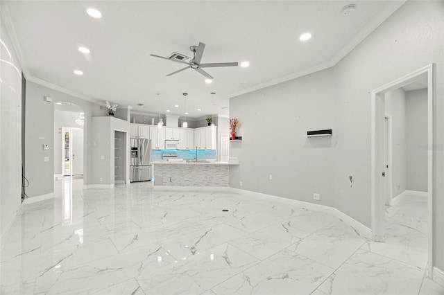 unfurnished living room with ceiling fan, sink, and ornamental molding