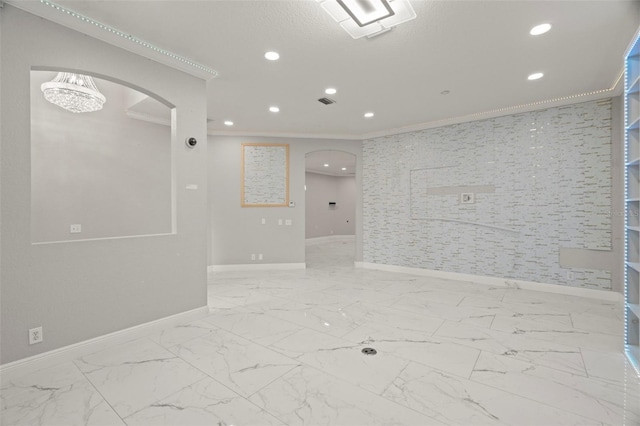 spare room featuring crown molding and a notable chandelier