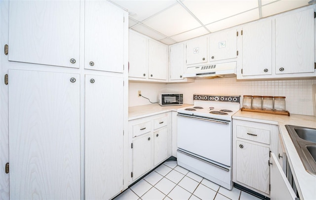 kitchen with a drop ceiling, range hood, white cabinets, white range with electric cooktop, and light tile patterned flooring