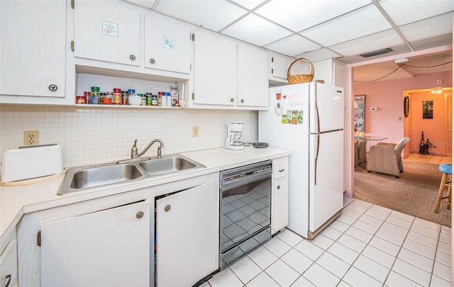 kitchen with sink, black dishwasher, white fridge, a paneled ceiling, and white cabinets