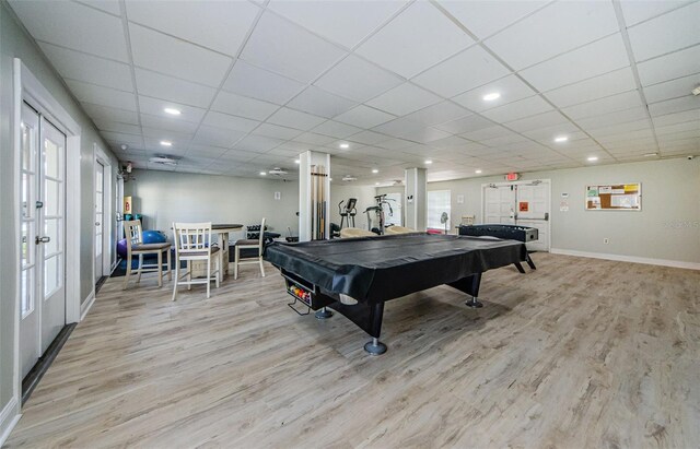 playroom featuring french doors, light hardwood / wood-style floors, a drop ceiling, and pool table