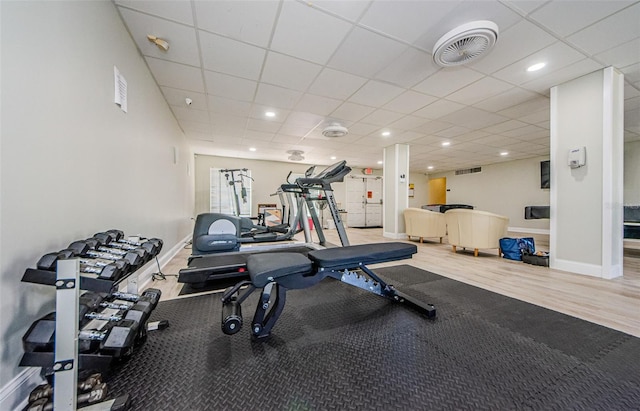 workout room featuring a drop ceiling and hardwood / wood-style flooring