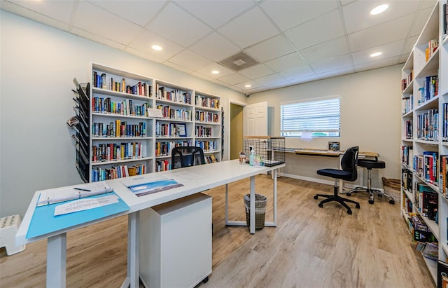 office with light wood-type flooring and a paneled ceiling