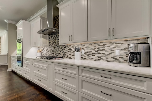 kitchen with tasteful backsplash, wall chimney exhaust hood, stainless steel appliances, dark hardwood / wood-style floors, and white cabinetry