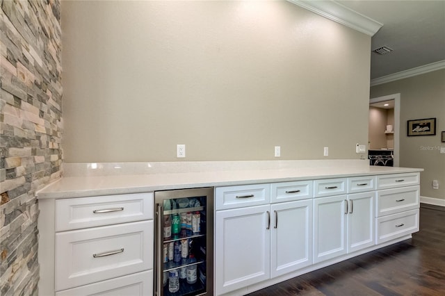 bar with white cabinets, beverage cooler, dark hardwood / wood-style floors, and ornamental molding