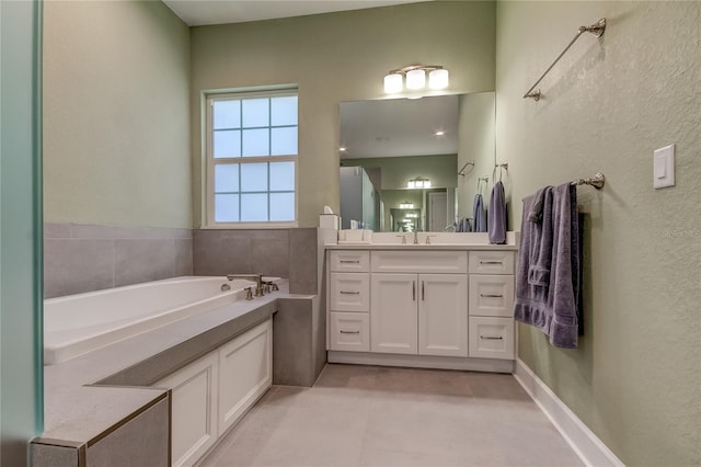 bathroom with a tub to relax in, tile patterned floors, and vanity