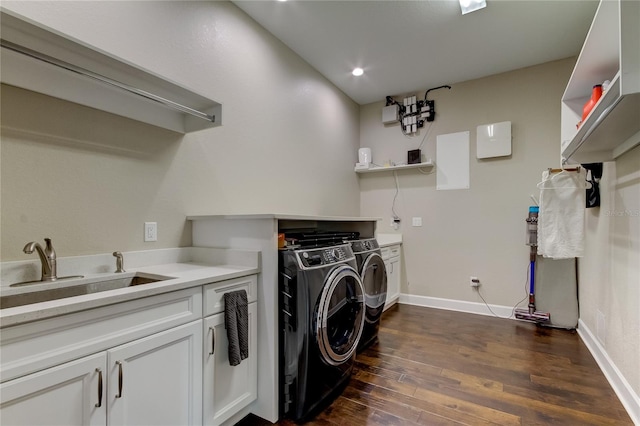 laundry room with cabinets, dark hardwood / wood-style floors, washer and clothes dryer, and sink