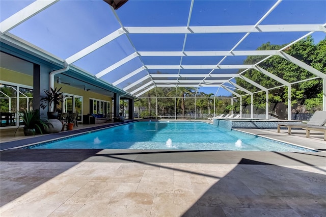 view of swimming pool with pool water feature, a patio, ceiling fan, and a lanai