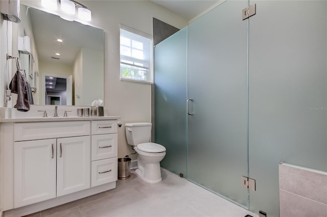 bathroom with tile patterned flooring, vanity, a shower with shower door, and toilet