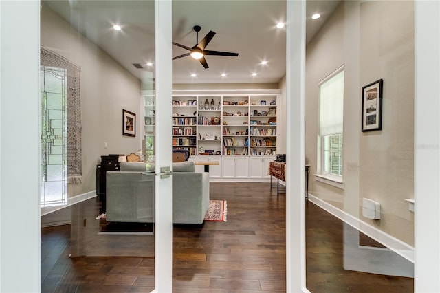 interior space with a wealth of natural light, ceiling fan, and dark hardwood / wood-style floors