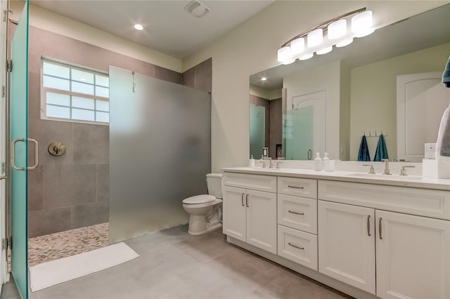 bathroom featuring tile patterned floors, vanity, toilet, and an enclosed shower