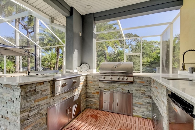 view of patio / terrace featuring sink, an outdoor kitchen, glass enclosure, and a grill