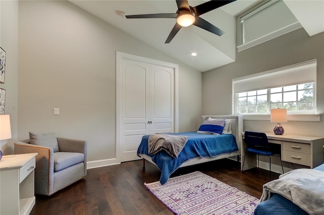 bedroom with ceiling fan, dark hardwood / wood-style floors, lofted ceiling, and a closet