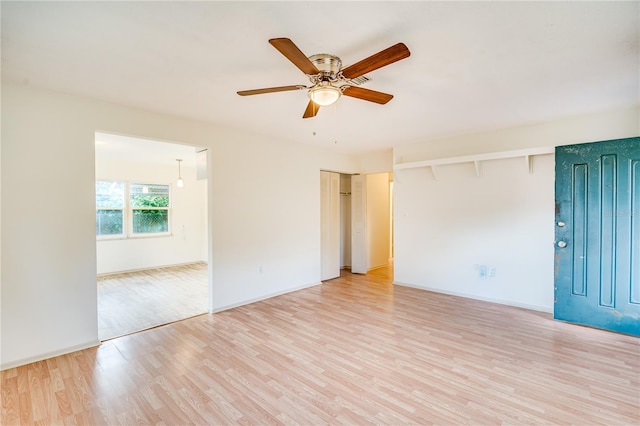 empty room with ceiling fan, beamed ceiling, and light hardwood / wood-style floors