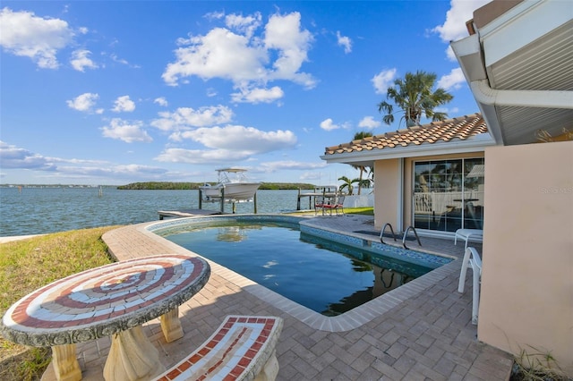 view of pool with a patio and a water view