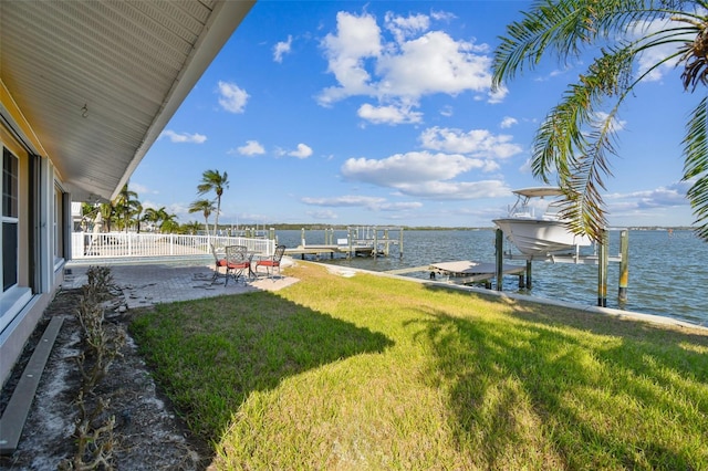 view of yard with a patio, a boat dock, and a water view